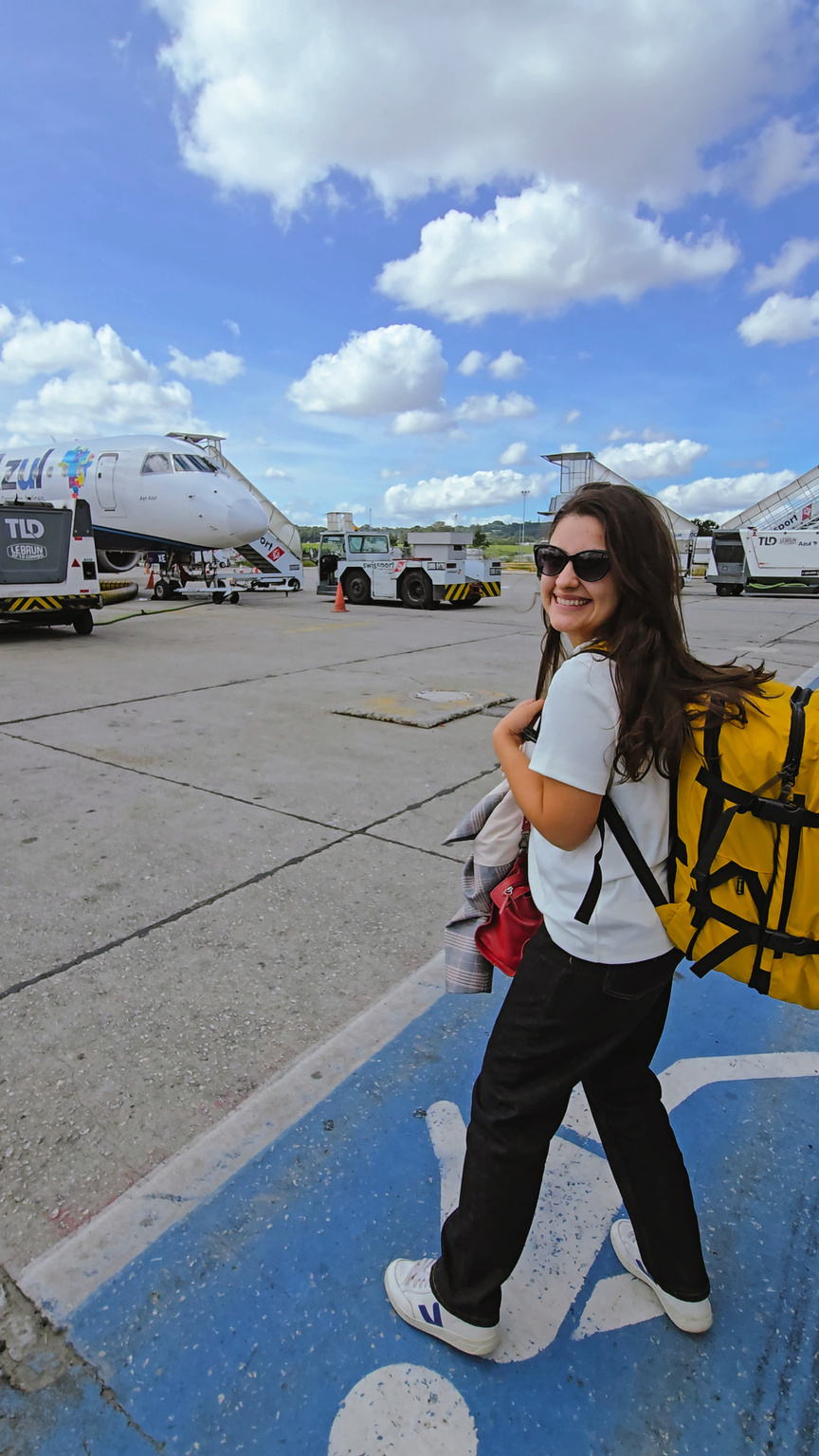 Thaís no aeroporto com mochila amarela